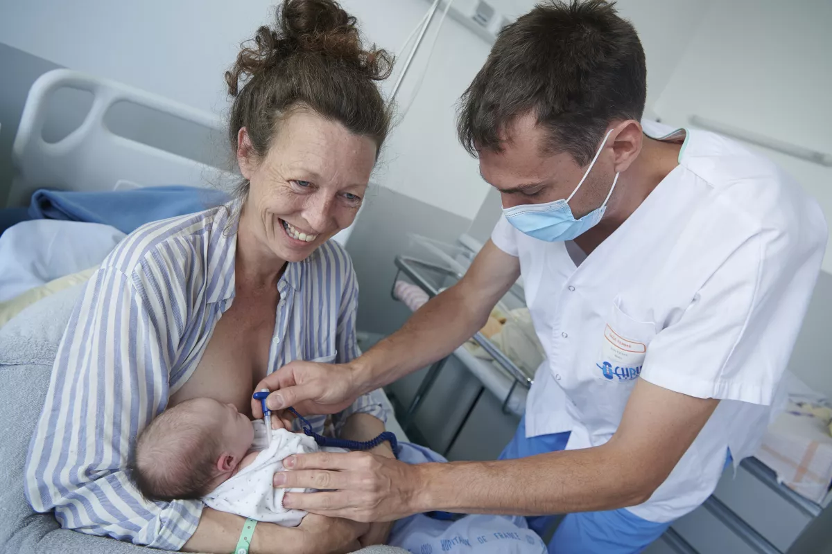 femme avec son nouveau né et un soignant